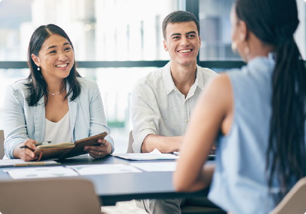 two people smiling sat across from someone else