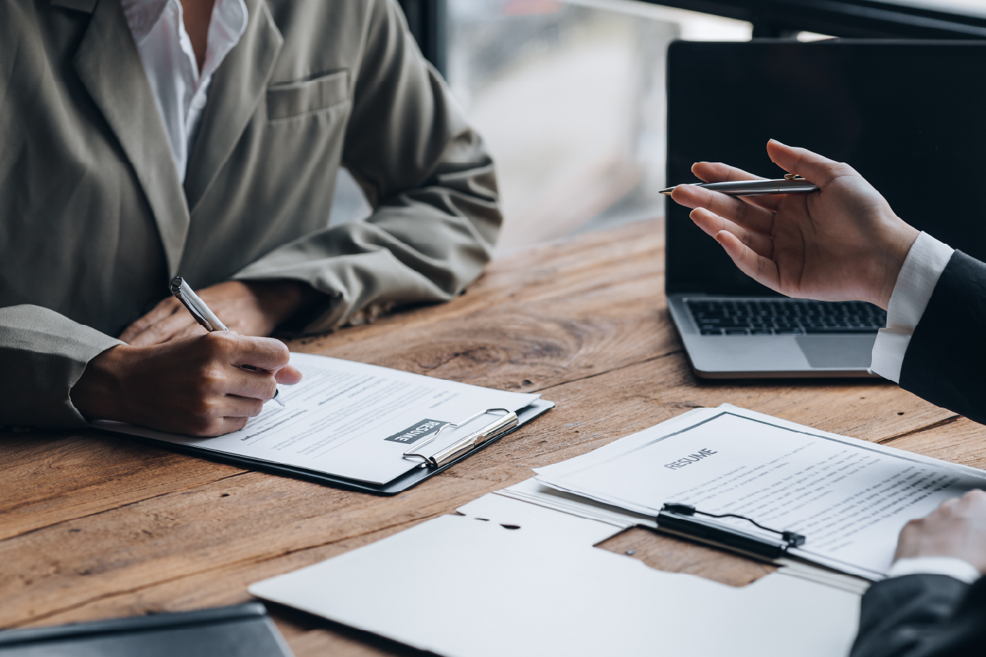 someone writing down on a piece of paper whilst someone is explaining something