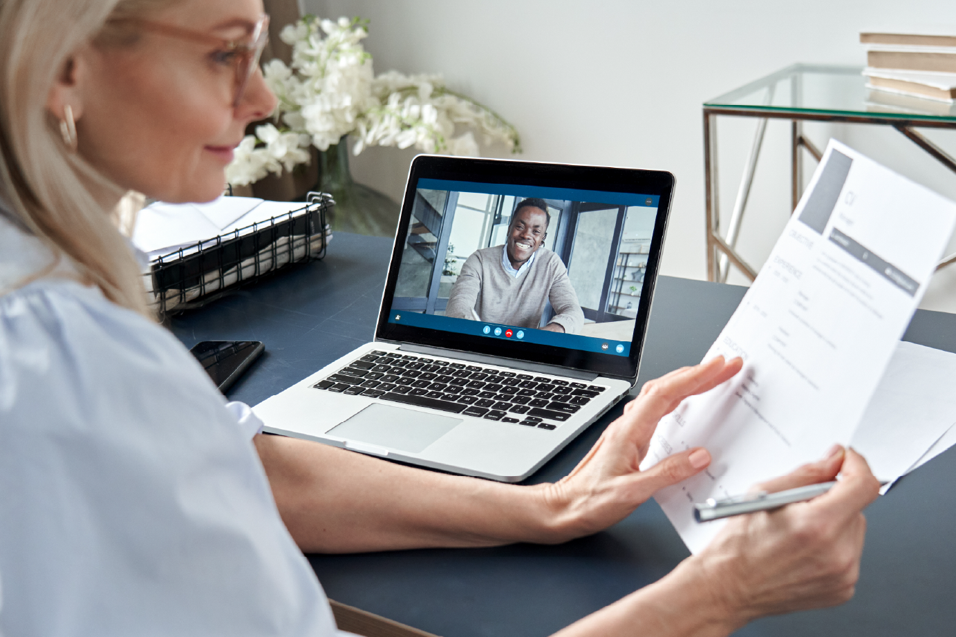 a lady whilst on a video call on her laptop reviewing a CV