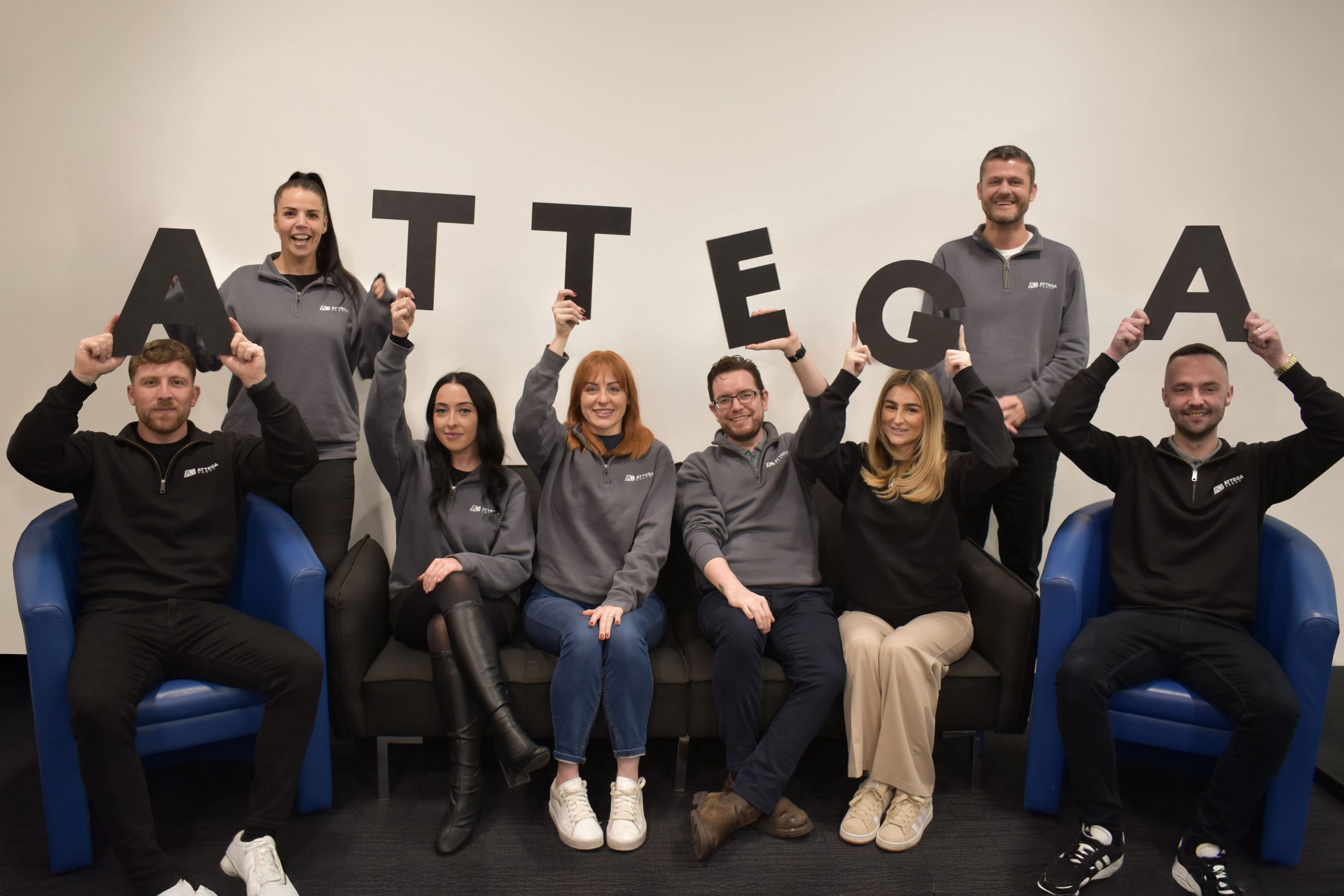 attega staff holding up letters for the story of attega